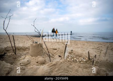Cuxhaven, Allemagne.07e octobre 2021.Les marcheurs passent devant un château de sable sur la plage de Cuxhaven.Au début des vacances d'automne en Rhénanie-du-Nord-Westphalie ce week-end, les régions de vacances de Basse-Saxe se préparent pour de nombreux clients.Credit: Sina Schuldt/dpa/Alay Live News Banque D'Images
