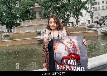 La Marche contre la fourrure NYC organisée par la Coalition pour abolir le commerce de la fourrure : des activistes attentionnés contre la fourrure dans le centre de Manhattan à New York le 9 octobre 2021.Des centaines de militants des droits des animaux se sont rassemblés sur le Grand Army Plaza pour le rassemblement et ont défilé à travers les rassemblements de mise en scène de Midtown Manhattan devant les boutiques de mode haut de gamme de Christian Dior, Moncler, Fendi, Dolce et Gabbana exigeant la fin de l'utilisation de la fourrure d'animaux à la mode.Les manifestants se sont également rassemblés contre des voitures de cheval et ont exigé que le conseil municipal adopte une loi pour les interdire dans les rues de New York.Une jeune femme a mis de la peinture rouge sur elle à symbol Banque D'Images