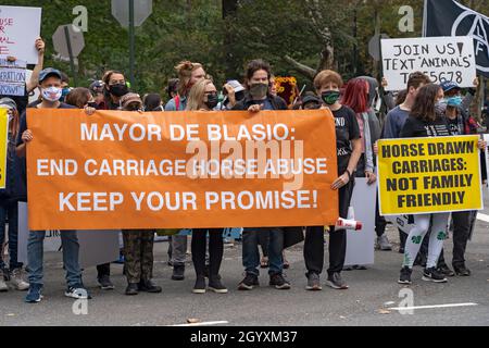 NEW YORK, NY - OCTOBRE 9: Les activistes des droits des animaux tiennent une bannière lisant "Mayor de Balsio end calèche abus Gardez votre promesse!"Et d'autres signes contre des voitures tirées par des chevaux sur la Cinquième Avenue le 9 octobre 2021 à New York.Les militants des droits des animaux de fur Free NYC, une coalition d'organisations à but non lucratif qui travaillent à l'interdiction de la vente de fourrures à New York, ont protesté pacifiquement en demandant aux New-Yorkais d'exhorter leurs membres du Conseil municipal de New York à soutenir le projet de loi Intro 1476 pour New York sans fourrure. Banque D'Images