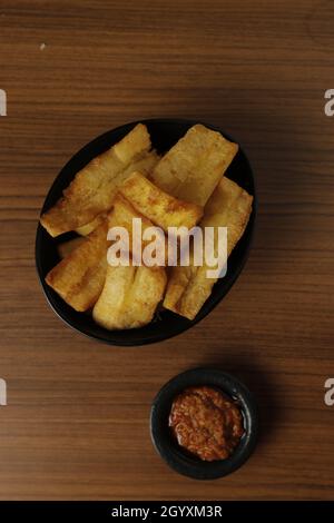 Patate douce frite à base de patate douce (Manihot esculenta) avec sauce Chili sur une table en bois. Banque D'Images