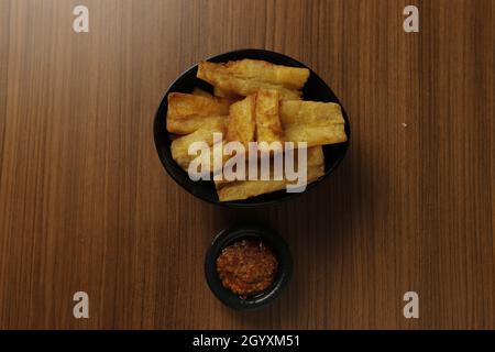 Patate douce frite à base de patate douce (Manihot esculenta) avec sauce Chili sur une table en bois. Banque D'Images