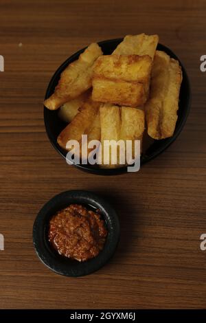 Patate douce frite à base de patate douce (Manihot esculenta) avec sauce Chili sur une table en bois. Banque D'Images