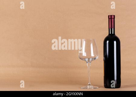 Bouteille de vin rouge et verre sur fond de papier. Banque D'Images