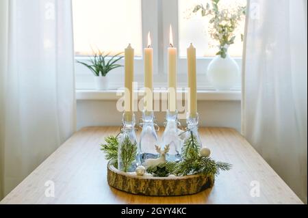 autre couronne de l'avent, bougies en bouteilles sur un panneau en bois avec décoration sur une table à la fenêtre, deux sont allumés, deuxième dimanche avant noël, Banque D'Images