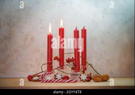 Quatre bougies rouges, deux sont allumées pour le deuxième dimanche avant Noël, décoration de l'Avent sur une table en bois contre un mur rustique, espace de copie, sélectionné Banque D'Images