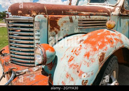 Gros plan d'un camion de récolte IH international rouillé d'époque avec peinture pelable garé à l'extérieur par une journée ensoleillée Banque D'Images