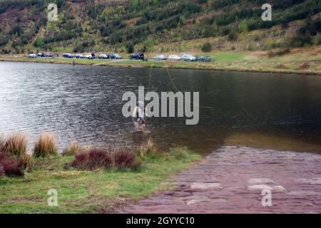 Lone Angler de Cockermouth Angling Association pêche à la mouche sur Cogra Moss Reservoir dans le Lake District National Park, Cumbria, Angleterre, Royaume-Uni Banque D'Images