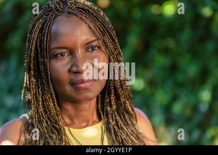 Portrait extérieur d'une femme africaine d'âge moyen ou afro-américaine d'âge moyen avec des cheveux tressés dans des tresses Banque D'Images