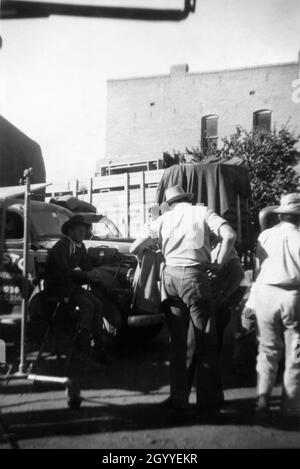 Photo de JOEL McCrea assis sur une chaise haute sur un terrain de jeu Candid avec Movie Crew à l'automne 1948 pendant le tournage à Durango du TERRITOIRE DU COLORADO 1949 réalisateur RAOUL WALSH scénario John Twist et Edmund H. North adapté du roman High Sierra par W.R.Burnet Warner Bros. Banque D'Images