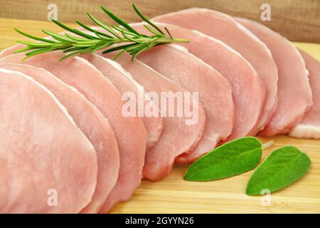 Viande de porc fraîche 10 steaks sur bois avec herbes Banque D'Images