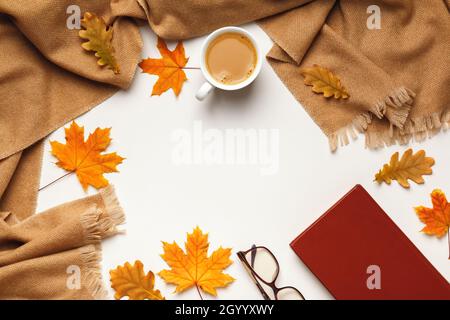 Foulard beige cachemire, tasse à café avec érable d'automne et feuilles de chêne livre de verres sur fond gris.Flat lay, vue de dessus, espace de copie Banque D'Images