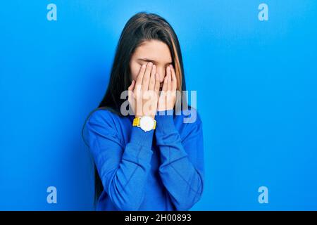 Jeune fille brunette portant des yeux de frottement de chandail de turtleneck pour la fatigue et les maux de tête, l'expression de sommeil et de fatigue. Problème de vision Banque D'Images