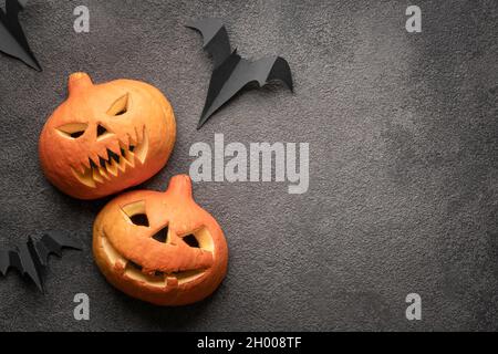 plat de citrouille d'halloween, photo d'espace de copie sur fond sombre modèle. Deux citrouilles d'automne effrayantes avec la tête de Jack, une maquette avec un grenin menaçant et Banque D'Images