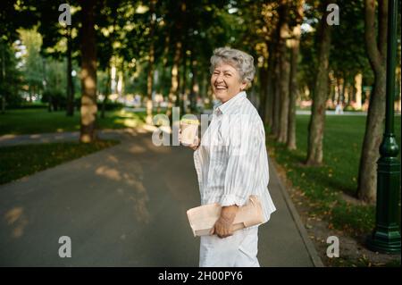 Drôle de boisson granny café dans le parc d'été Banque D'Images