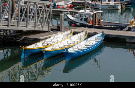 Newlyn Harbour, Cornwall, Angleterre, Royaume-Uni.2021. Trois bateaux-pilotes de gig sur une jetée dans le port de Newlynn. Banque D'Images