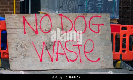 aucun signe de perte de chien grande main fait peinture rouge sur le vieux panneau en bois appuyé contre les barrières orange sur le chantier de construction Banque D'Images