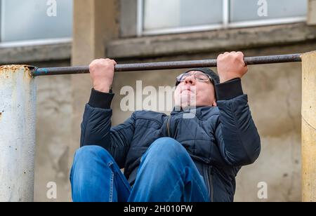 humour, un homme adulte tire sur une barre horizontale Banque D'Images