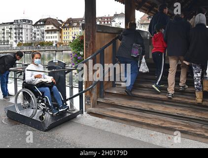 Ascenseur accessible en fauteuil roulant utilisé par une jeune femme sur le pont de la chapelle de Lucerne, en Suisse Banque D'Images