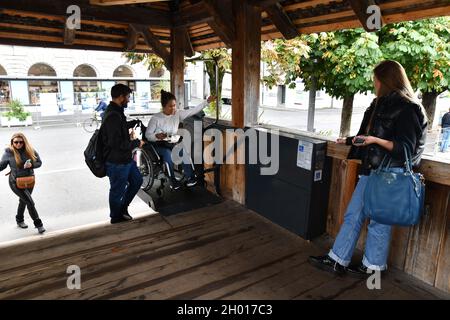 Ascenseur accessible en fauteuil roulant utilisé par une jeune femme sur le pont de la chapelle de Lucerne, en Suisse Banque D'Images