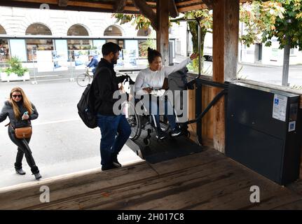 Ascenseur accessible en fauteuil roulant utilisé par une jeune femme sur le pont de la chapelle de Lucerne, en Suisse Banque D'Images