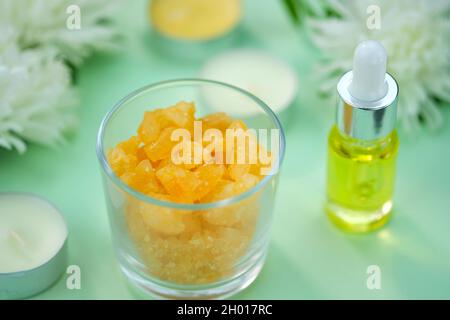 Sel de mer dans un verre avec l'odeur de l'huile d'orange et de thé, bougies sur un fond vert.Le thème de la relaxation, de la baignade, de la relaxation en soirée.Mer sal Banque D'Images