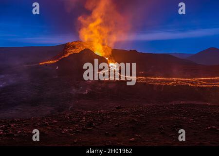 Éruption volcanique en Islande.Cratère du volcan Fagradalsfjall la nuit au ciel bleu avec lave liquide.Volcan sur la péninsule de Reykjanes Banque D'Images