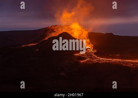 Vue sur l'éruption volcanique en Islande.Cratère du volcan Fagradalsfjall la nuit au ciel bleu avec lave liquide.Volcan sur les Reykjanes Banque D'Images