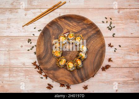 Vue de dessus image d'un rouleau de sushi uramaki dans tempura frit farci de saumon avec avocat et algues nori Banque D'Images