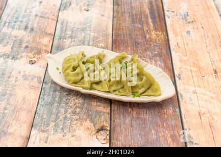 Servir de gyozas de légumes cuits à la vapeur avec de la ciboulette et sur une belle assiette blanche Banque D'Images