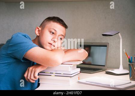 Un jeune garçon se couche sur une pile de livres Banque D'Images