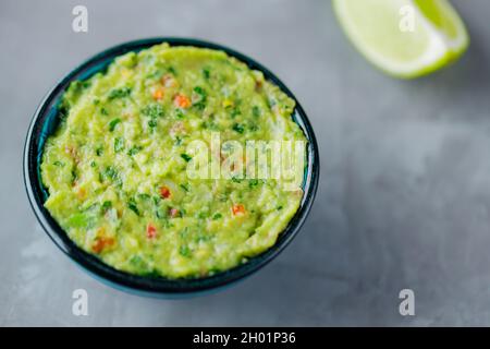 Bol de guacamole sur fond gris.Sauce mexicaine traditionnelle guacamole dans le bol.Cuisine mexicaine.Copier l'espace.Vue de dessus Banque D'Images