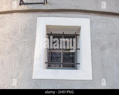 Barres de métal sur les fenêtres d'une vieille maison ronde.Fragment d'un bâtiment historique. Banque D'Images