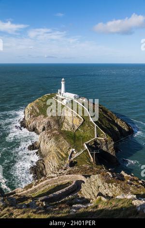 Vue sur le magnifique phare de South Stack à la pointe d'Anglesey sur la côte nord du pays de Galles en octobre 2021 tandis que les vagues longent les falaises escarpées Banque D'Images