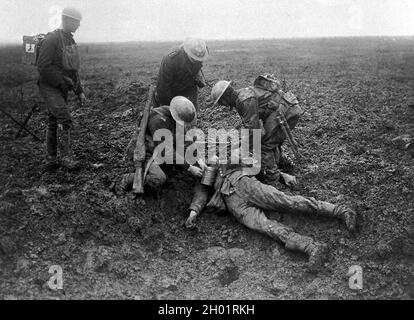 Des soldats canadiens s'occupent d'un Allemand tombé sur le champ de bataille de la crête de Vimy en 1917. Banque D'Images