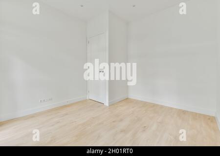 Une photo intérieure d'une pièce vide avec des murs blancs et un parquet Banque D'Images