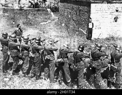 Georges Blind, membre de la résistance française, souriant devant une équipe de tir allemande en 1944. Banque D'Images