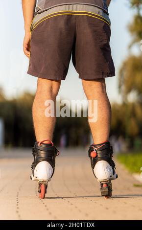 Photo verticale des jambes d'un homme patinant avec des patins à roues alignées Banque D'Images