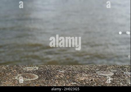Coloration brune / coloration à la scène de rivière et d'eau hors foyer avec le premier plan de béton Banque D'Images