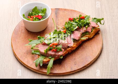 Un sandwich à la baguette avec un steak de bœuf sous vide et une sauce aux herbes chimichurri Banque D'Images