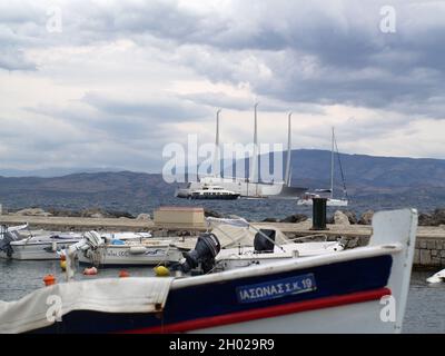 Le plus grand yacht du monde 'Sailing Yacht A' ancré au large de la rive dans la baie de Garitsa, Corfou, Grèce, avec de petits bateaux en premier plan Banque D'Images