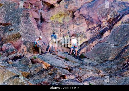 3 août 2014 Eldorado Springs Colorado USA; un groupe de jeunes grimpeurs de roche se préparent à faire leur chemin vers le haut de la face d'énormes rochers et falaises dans l'eld Banque D'Images