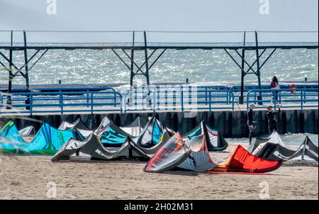 St Joseph MI USA, 26 septembre 2021 ; un grand groupe de cerfs-volants se reposent sur le sable, alors que les gens attendent le vent pour reprendre sur le lac Michigan Banque D'Images