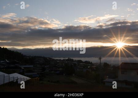 IIDA, Nagano, Japon, 2021-11-10, nuages illuminés par le soleil au lever du soleil en début de matinée sur la ville d'Iida, à Nagano, Japon. Banque D'Images