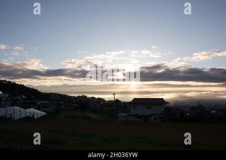 IIDA, Nagano, Japon, 2021-11-10, nuages illuminés par le soleil au lever du soleil en début de matinée sur la ville d'Iida, à Nagano, Japon. Banque D'Images