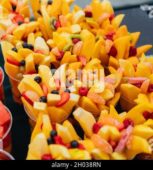 Salade de fruits frais disposée dans des tasses en plastique sur un marché Banque D'Images