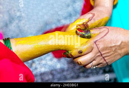 Une pâte de haldi curcuma de la mariée indienne sur sa main Banque D'Images