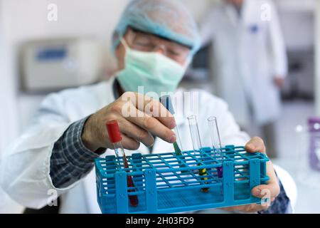 Gros plan de la main du médecin tenant le tube à essai avec des produits chimiques Banque D'Images