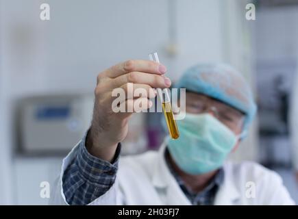 Gros plan de la main du médecin tenant le tube à essai avec des produits chimiques Banque D'Images