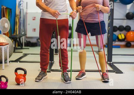 Entraîneur personnel aidant une femme handicapée dans son entraînement Banque D'Images