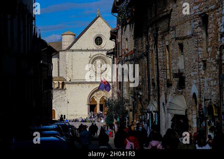 Vue générale de la via San Francesco touristes marchant dans le centre historique d'assise, au bout de la rue la basilique de San Francesco Banque D'Images